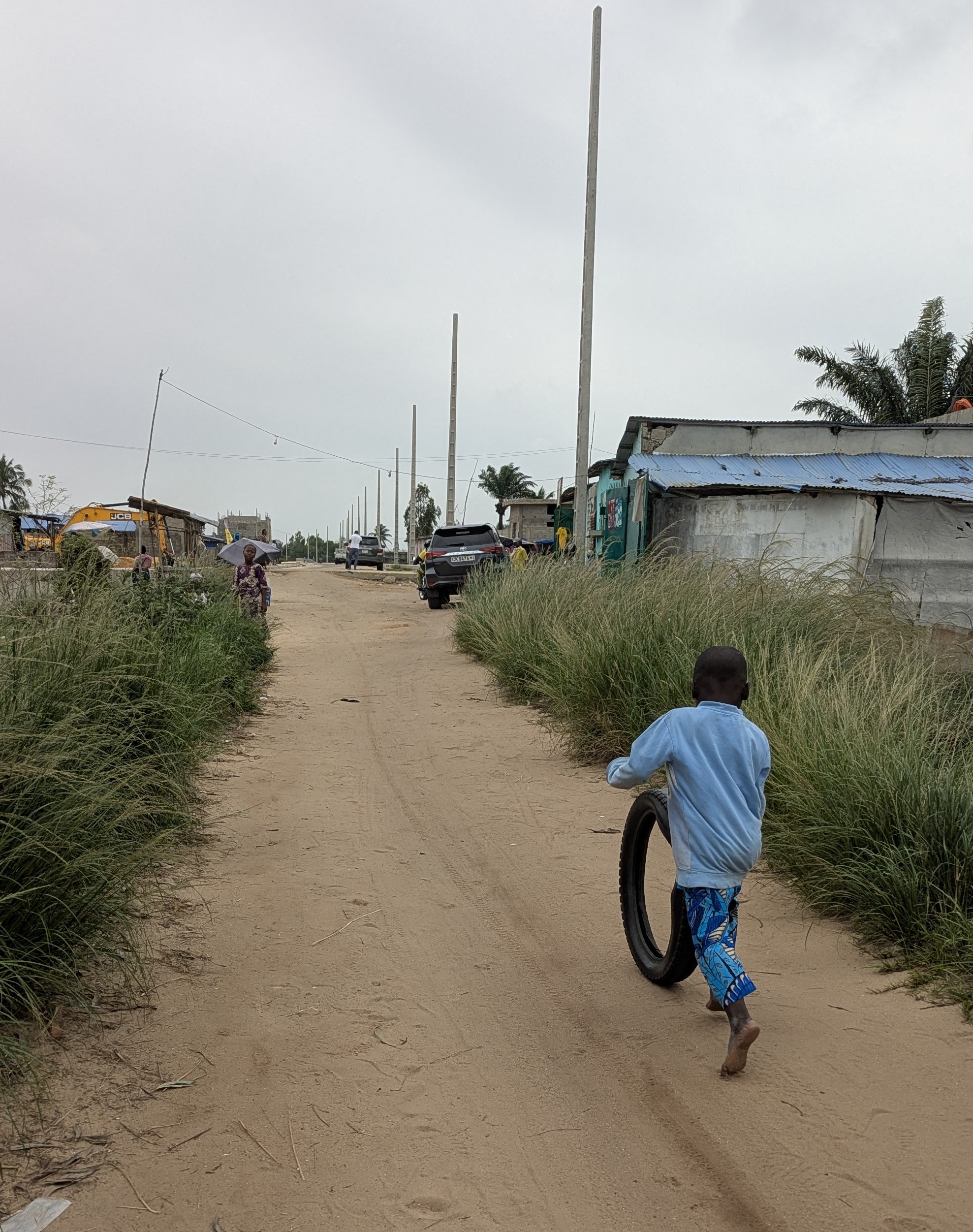 A child seen from behind walking down the street in Benin