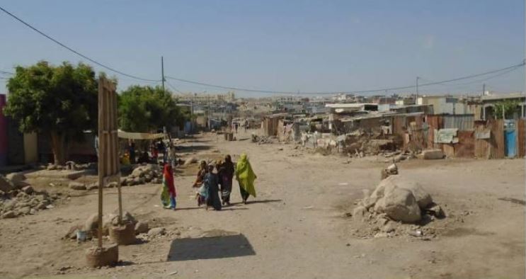 People walking in the street in djibouti with infrastructures in the background
